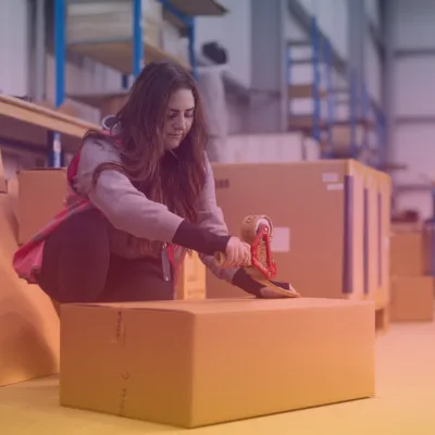 Staff member taping parcel with a coloured overlay